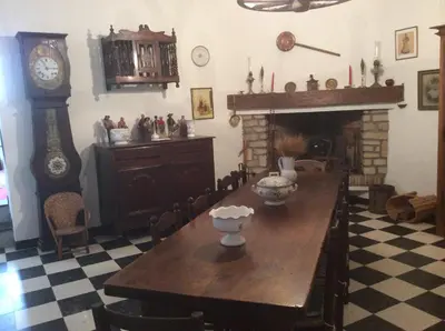 a dining room with a table and a grandfather clock at Maison Daumas Billard Français et Piscine in Robion en Luberon
