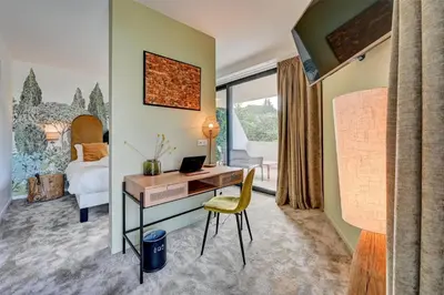 a hotel room with a desk and a bedroom at Best Western Sévan Parc Hôtel in Pertuis