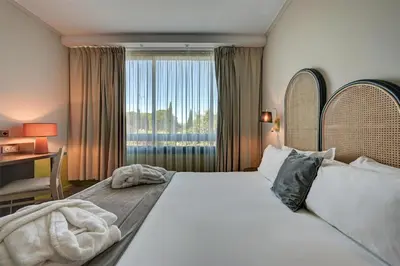 a bedroom with a large bed with a window at Best Western Sévan Parc Hôtel in Pertuis