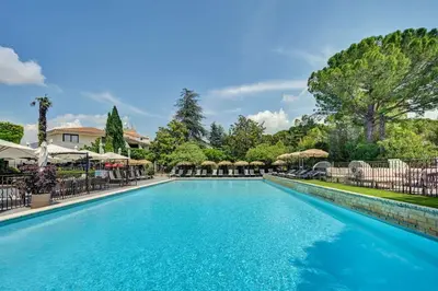 a swimming pool at a resort with umbrellas at Best Western Sévan Parc Hôtel in Pertuis