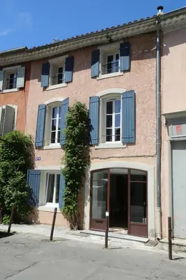 a large brick building with blue shuttered windows at La Bignone in LʼIsle-sur-la-Sorgue