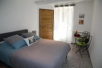 a bedroom with a large bed and a window at La Bignone in LʼIsle-sur-la-Sorgue