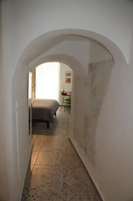 a hallway with an archway with a bed in a room at La Bignone in LʼIsle-sur-la-Sorgue