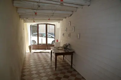 a hallway with a table in a room with a window at La Bignone in LʼIsle-sur-la-Sorgue