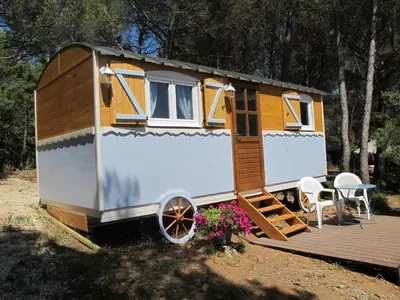 a yellow and white trailer with a wooden deck at L'Oustau de Bigatié in Lambesc