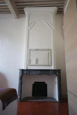 a fireplace with a mirror above it in a room at Appartement de caractère entre St Rémy et Avignon, 74m2, 2 à 4 personnes in Noves