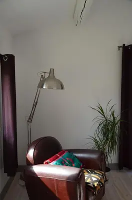 a brown leather chair sitting next to a lamp at Les cabanes de Vallis Clausa in Saumane-de-Vaucluse