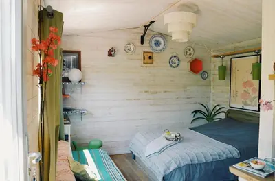 a small room with a bed and plates on the wall at Les cabanes de Vallis Clausa in Saumane-de-Vaucluse