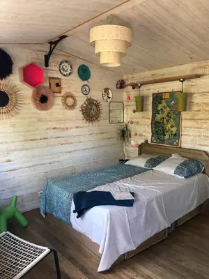 a bedroom with a bed in a room with wooden walls at Les cabanes de Vallis Clausa in Saumane-de-Vaucluse