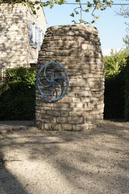 a stone wall with a blue sculpture on it at Villa Les Carlets in Saignon