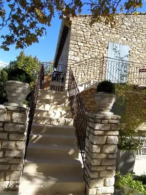 a staircase leading to a building with a stone wall at Villa Les Carlets in Saignon