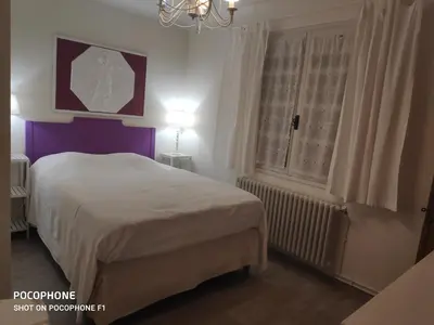 a bedroom with a white bed and a window at Villa Les Carlets in Saignon
