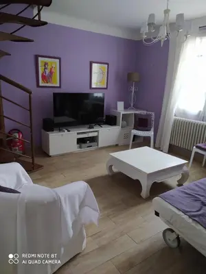 a living room with purple walls and a tv at Villa Les Carlets in Saignon