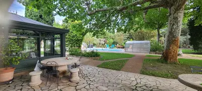 a house with a picnic table in a park at Gîte familial de charme, piscine chauffée en Provence in Le Thor