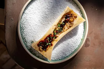 a piece of food on a plate with powdered sugar at Hotel La Bastide d'Eygalières in Eygalières