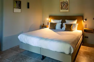 a bedroom with a large bed with white sheets and pillows at Hotel La Bastide d'Eygalières in Eygalières