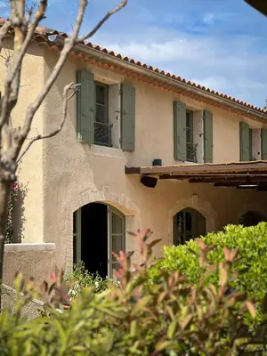 a house with green shutters on the side of it at Hotel La Bastide d'Eygalières in Eygalières