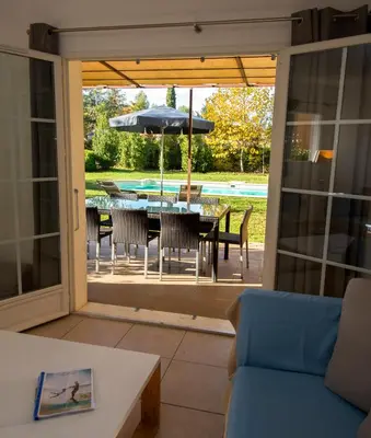 a patio with a table and chairs and an umbrella at Lagrange Vacances - Le Clos Savornin in Saint-Saturnin-les-Apt