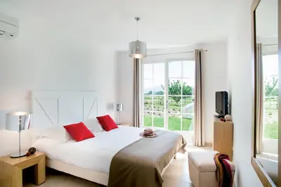 a bedroom with a large white bed with red pillows at Lagrange Vacances - Le Clos Savornin in Saint-Saturnin-les-Apt
