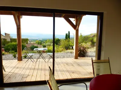 a room with a large glass door with a wooden deck at Maison Itzé in Saint-Saturnin-les-Apt