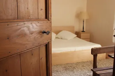 a bedroom with a bed and a wooden door with a drawer at Mas de la Gonnette in Venasque