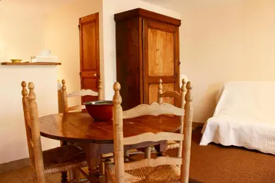 a room with a wooden table and a bed at Mas de la Gonnette in Venasque