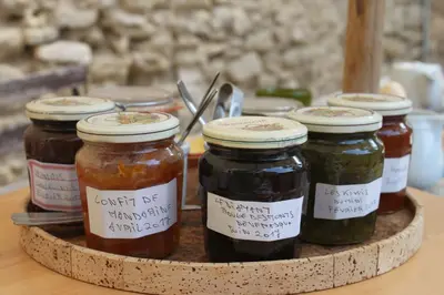 a group of jars of jam on a wooden tray at Mas de la Gonnette in Venasque