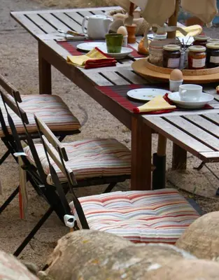 a wooden table with chairs and plates of food on it at Mas de la Gonnette in Venasque