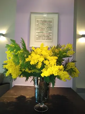 a vase filled with yellow flowers on a table at APPART AIX MAZARIN in Aix-en-Provence