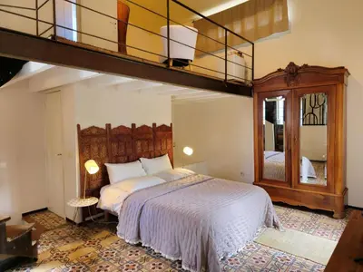 a bedroom with a large bed with a loft at Ancien Mas Du Moulin in Eygalières