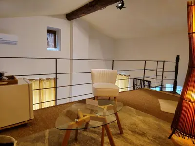 a living room with a chair and a glass table at Ancien Mas Du Moulin in Eygalières