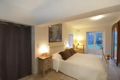 a bedroom with a white bed and a window at Ancien Mas Du Moulin in Eygalières
