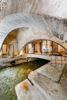 an old stone building with a river in it at La Prévôté - Luxury Chambres d'hôtes & Gastronomic Restaurant in LʼIsle-sur-la-Sorgue