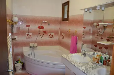 a bathroom with a tub and a sink at Les Vallons Holiday Home in Lioux