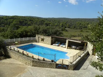 a large swimming pool in a stone building with at Les Vallons Holiday Home in Lioux