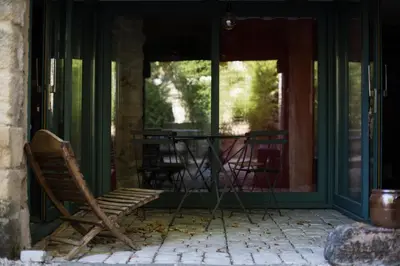 a porch with a rocking chair and a table at La Belugue in Beaumont-de-Pertuis