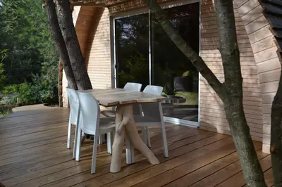 a wooden table and chairs on a deck at Cabanons Jour & Nuit in Mazan
