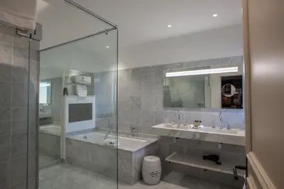 a bathroom with a shower and two sinks and a tub at Le Phébus & Spa – Relais & Châteaux in Joucas