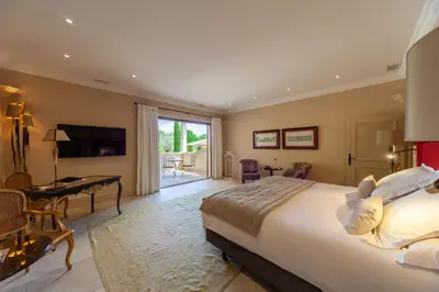a bedroom with a bed and a desk and a television at Le Phébus & Spa – Relais & Châteaux in Joucas