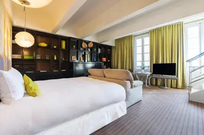 a bedroom with a bed and a couch and a television at Hôtel Particulier Le 28 - Spa & Art Luxury Design in Aix-en-Provence