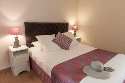 a bedroom with a bed with a hat on it at Hotel Sainte Anne - Apt in Apt