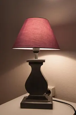 a lamp with a red lamp shade on a table at Hotel Sainte Anne - Apt in Apt