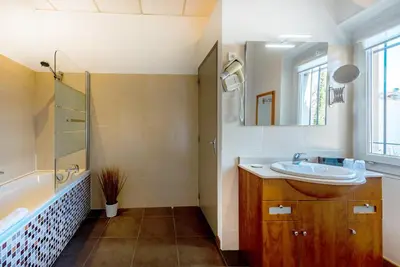 a bathroom with a sink and a tub and a mirror at Hotel Sainte Anne - Apt in Apt