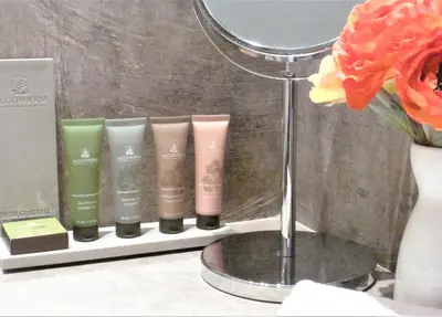 a shelf with a group of products in front of a mirror at Les Terrasses - Gordes in Gordes