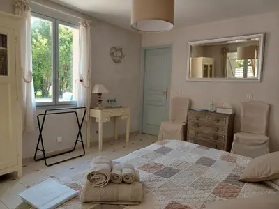 a bedroom with a bed and a dresser and a mirror at Mas des Cigognes in Le Thor