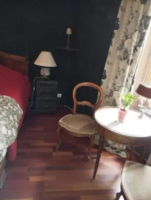 a bedroom with a bed and a chair and a table at Suite Provençale in Saignon