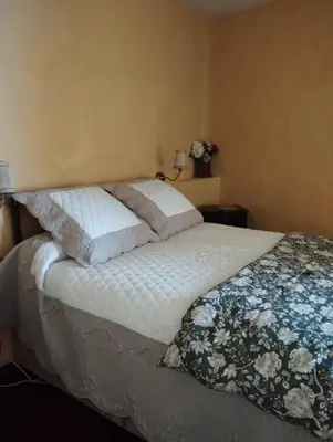 a bed with white sheets and pillows in a bedroom at Suite Provençale in Saignon