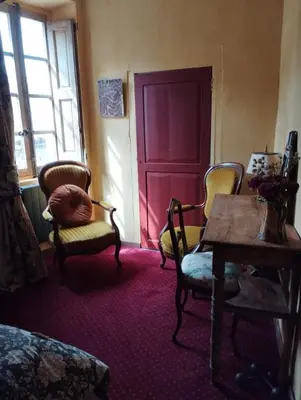 a room with two chairs and a table and a red door at Suite Provençale in Saignon