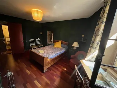a bedroom with a bed and two chairs at Suite Provençale in Saignon