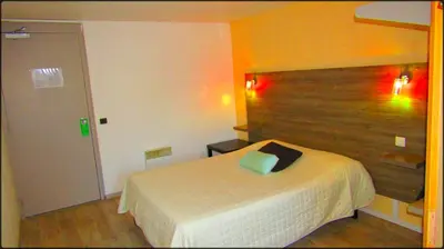 a bedroom with a bed and a wooden headboard at Aix Hotel in Aix-en-Provence